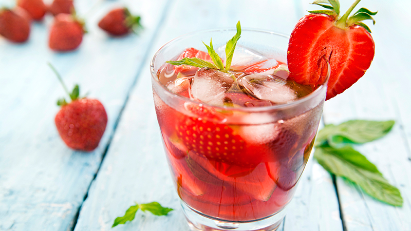 Glass of cocktail garnished with strawberry