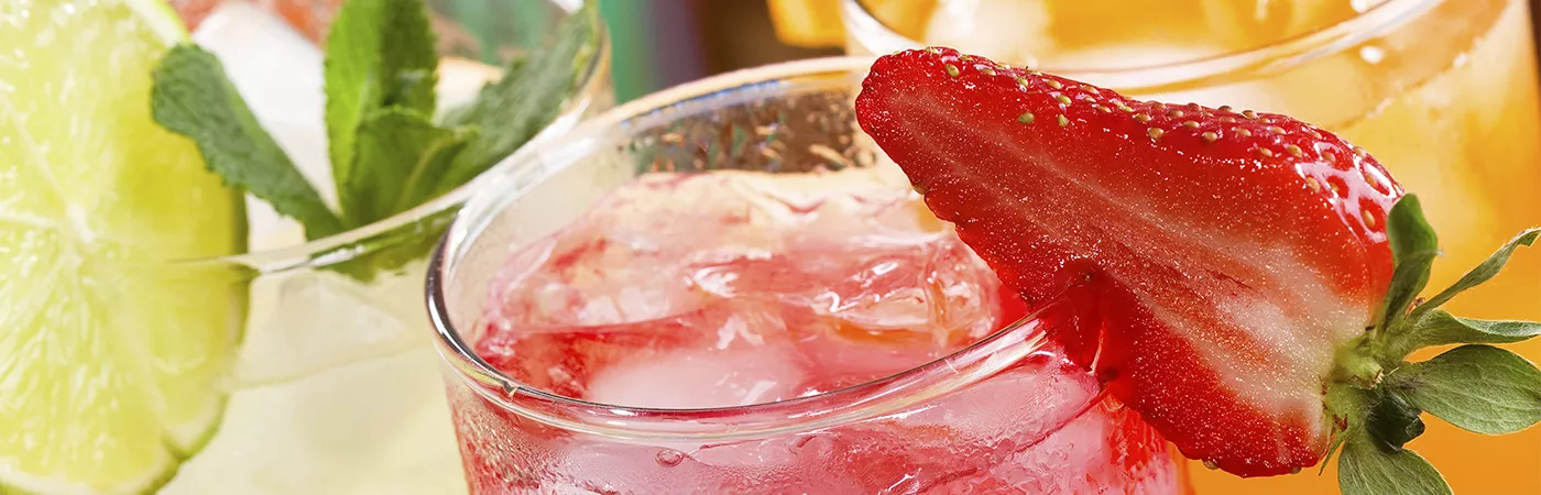 Glass of cocktail garnished with strawberry