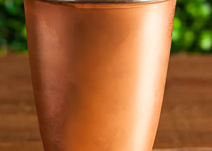 Glass of Berry Moscow Mule with raspberries and mint leaves