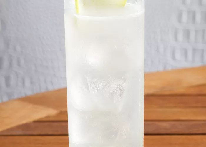    	 Glass of EFFEN® Green Apple Cooler garnished with apple slice on green coaster