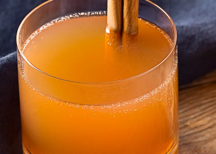 Glass of Spiced Christmas Punch garnished with cinnamon stick
