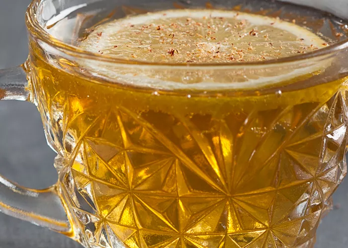 Cup of Fancy Bourbon Punch garnished with lemon slice