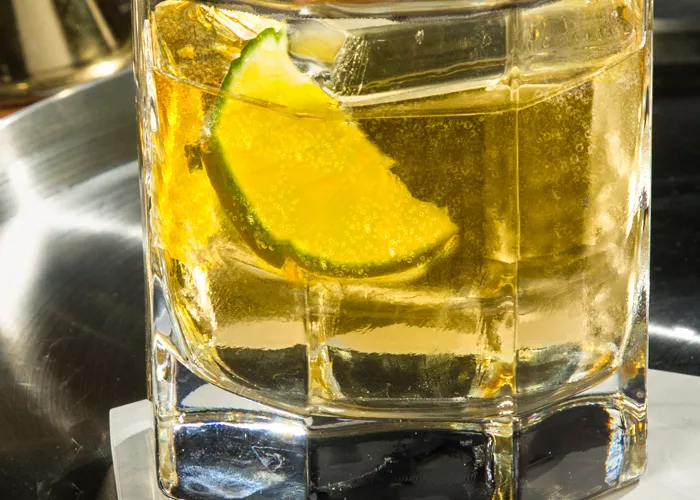 A glass of CC® Ginger Ale garnished with Lime Wedge