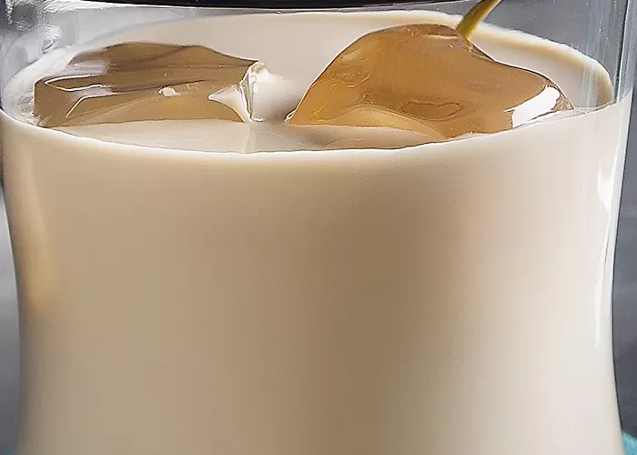 Glasses of White Russian with ice and cocktail pick on a blue napkin