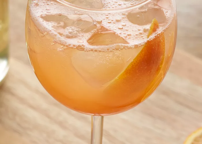 A Toki® Highball with grapefruit peel and a copper spoon is set on the kitchen slab.