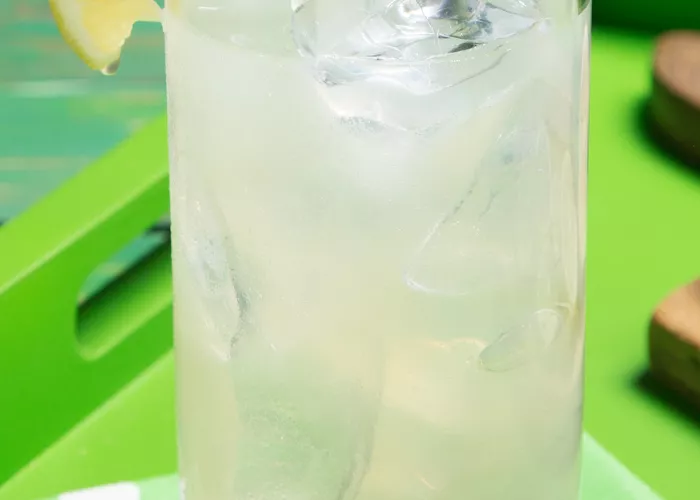 A glass of Limonlicious garnished with Lemon Wedge