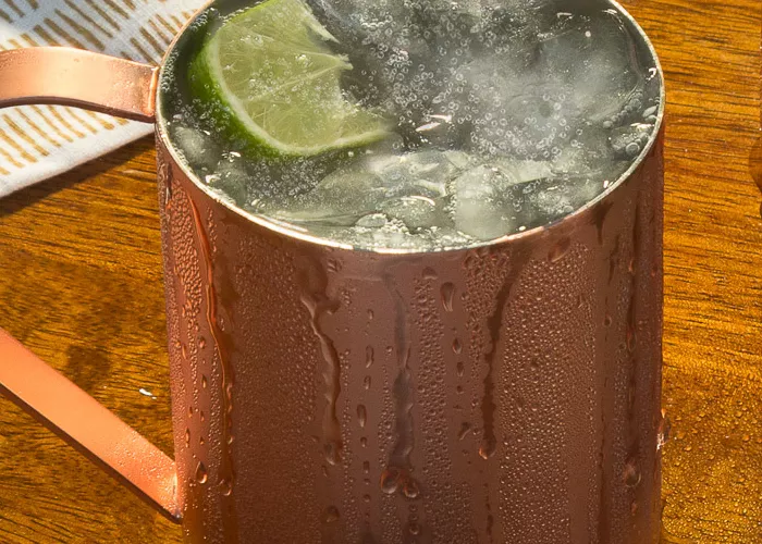 A copper cup of Pinnacle® Mule garnished with Lime Wedge