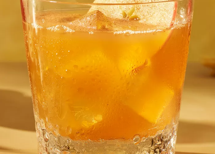A glassof SQRRL® An Apple A Day garnished with Fresh Apple Slices 