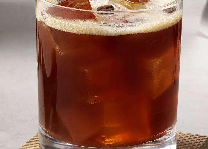 A glass of SQRRL® Carajillo garnished with Coffee Beans 