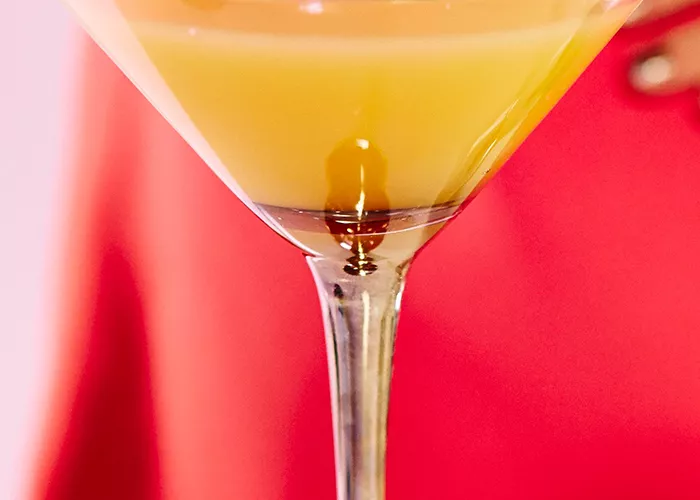 A cocktail glass of Orange Coco-Naut Cosmos.