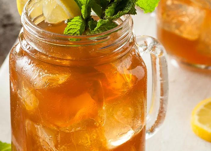 A pitcher of Harbor Punch garnished with lemon slice and fresh mint.