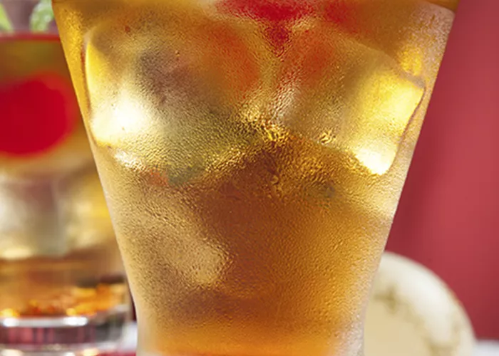 Two glasses of Spiced Cherry Sipper garnished with cherry and mint leaves