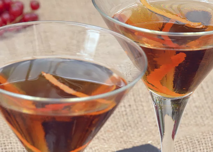 Glass of Take 9 garnished with orange twist