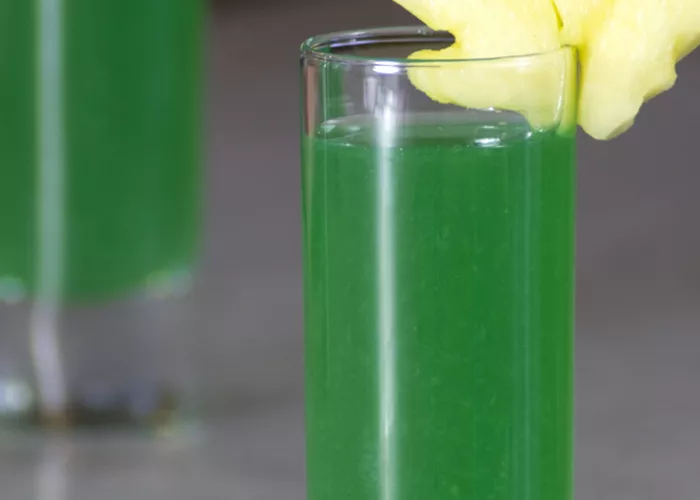 Two Glasses of Green Haze garnished with leaf shaped fruit