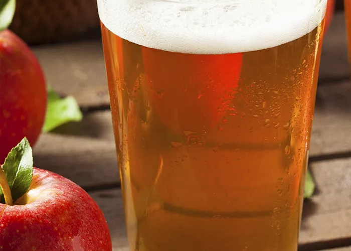 Glass of Beam® Applebees alongside two apples on a table.