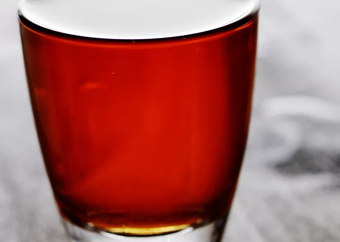 a glass of Fire Apple garnished with a lime wedge