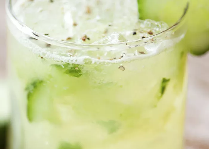 Glass of Honey Apple Cucumber garnished with a cucumber slice on the rim