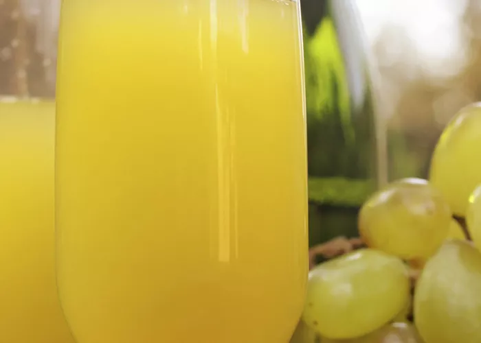 Two glasses of Alligator's Kiss, accompanied by a bowl full of grapes.