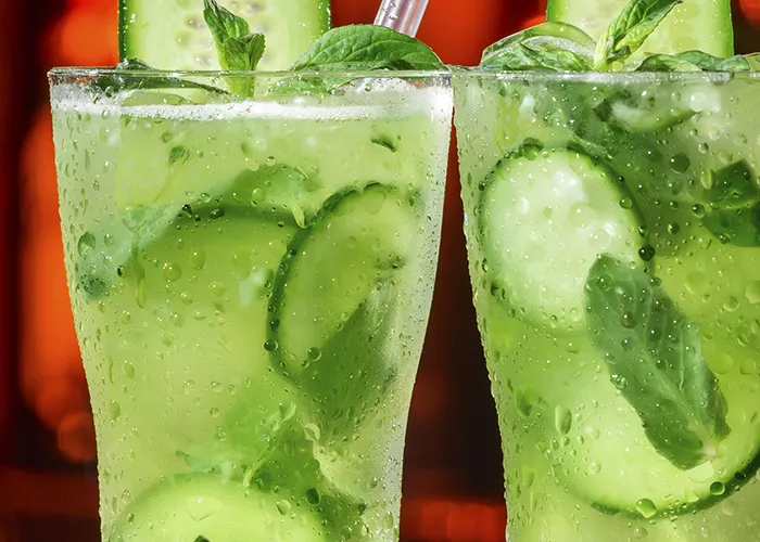 two glasses of Garden Delight garnished with cucumber and mint leaves