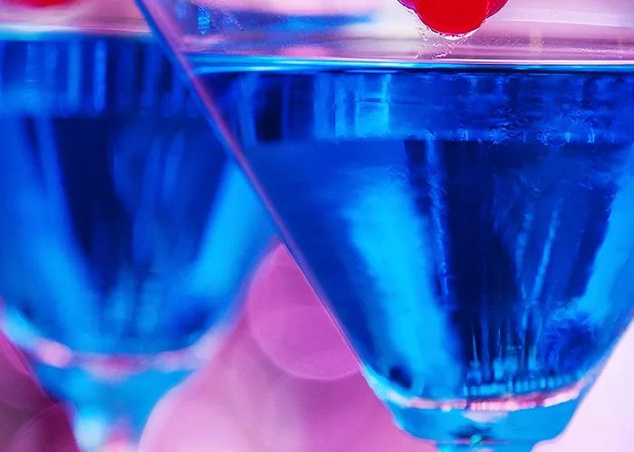 Two glass of Blue Martini garnished with cherry on a rim of glass