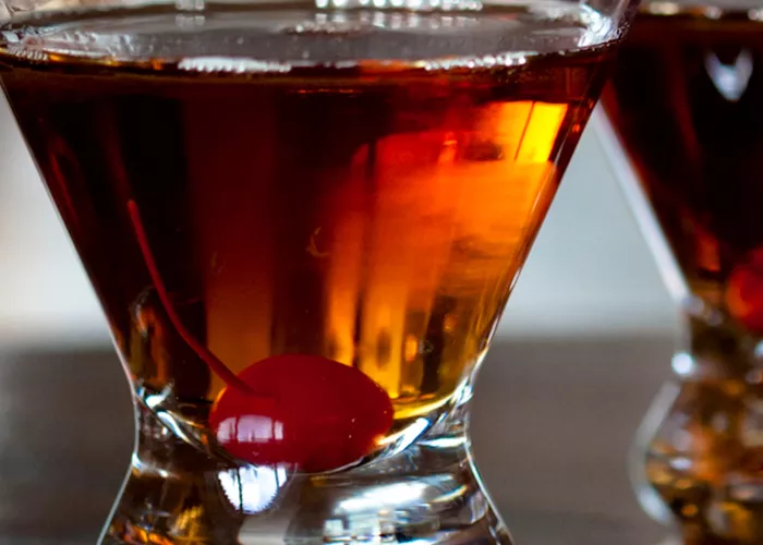 Two glasses of Classic Manhattan, each garnished with a cherry