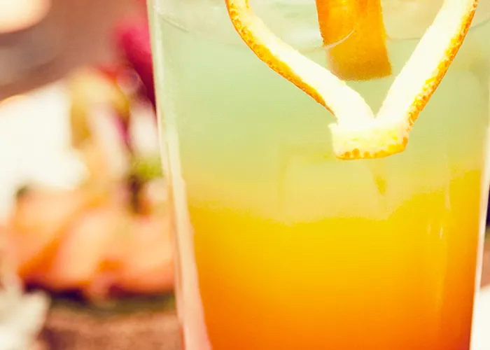Glass of Hurricane garnished with heart made of orange peel