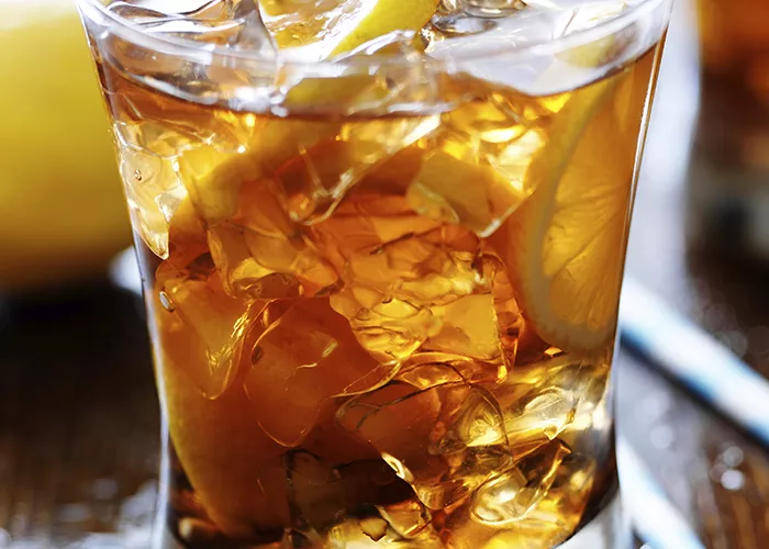 Glass of Kentucky Sweet Tea garnished with ice and lemon slices