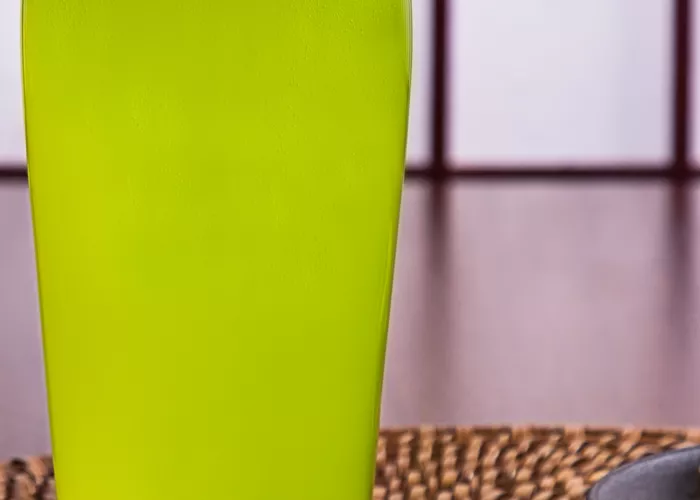 a glass of Midori and ginger beer liquid on a table