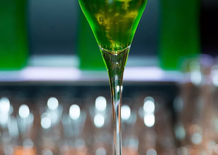 Glass of Midori® Sparkle with a lemon inside.
