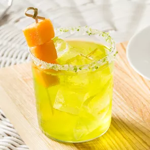 Glass of Cucumber Melon Margarita garnished with melon cubes