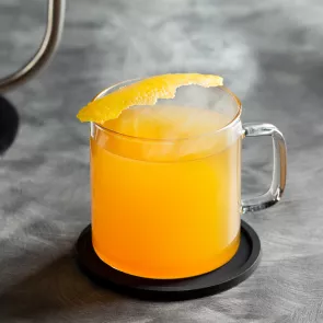 Cup of Jim Beam® Black Hot Toddy garnished with lemon peel on coaster