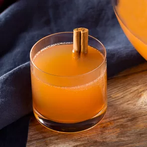 Glass of Spiced Christmas Punch garnished with cinnamon stick