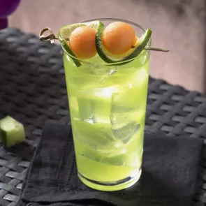 Glass of Melon Cooler garnished with melon ball and lemon slice