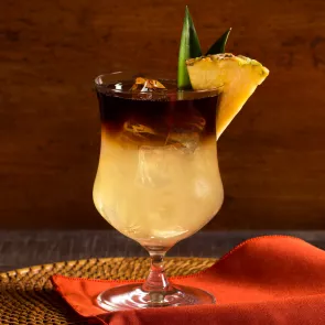Glass of Cruzan® Mai Tai garnished with pineapple wedge and leaf 
