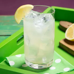 A glass of Limonlicious garnished with Lemon Wedge
