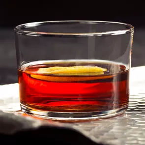 A glass of Hornitos® Black Barrel® Tequila Manhattan placed on the silver tray, garnished with orange peel.