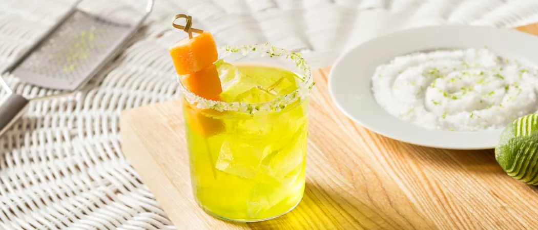 Glass of Cucumber Melon Margarita garnished with melon cubes