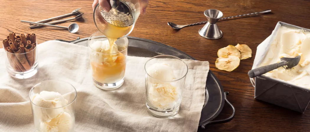 Person pouring Apple Cider Float into glass with icecream