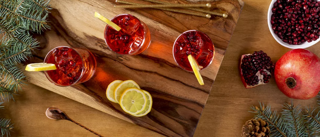 A wooden cutting board with a variety of fruits and other items placed on top.
