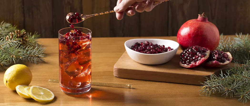 A person pouring a drink into a glass.