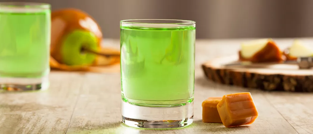 Two glass filled with  caramel apple shot