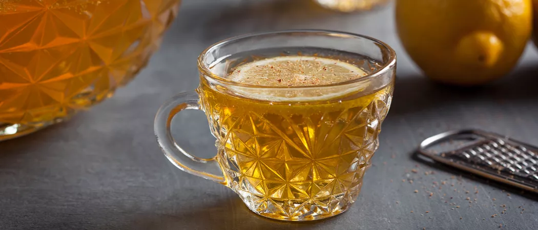 Cup of Fancy Bourbon Punch garnished with lemon slice