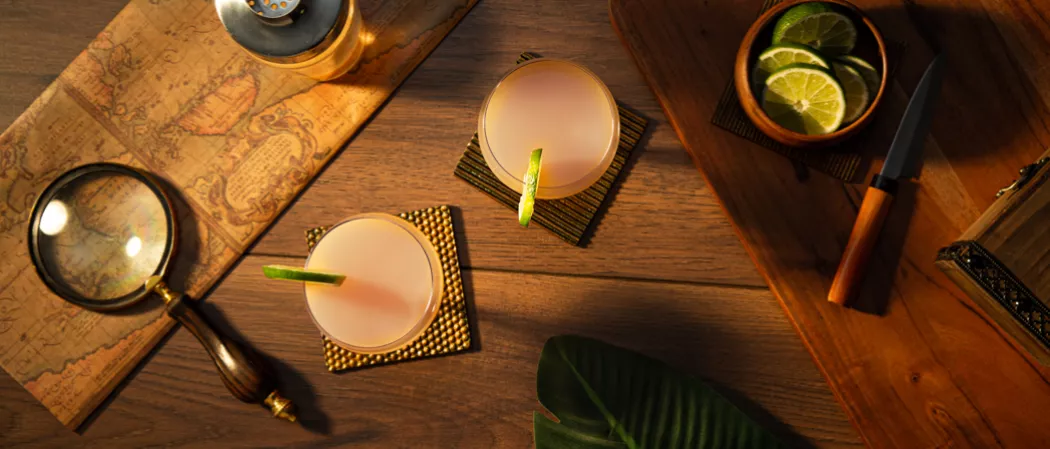 Two glasses of Hemingway Daiquiri garnished with Lime Wheel along with bowl of chopped lemons