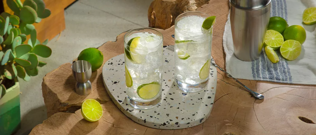 Two glasses of Hornitos® Ranch Water garnished with Lime Wedge along with chopped lemons