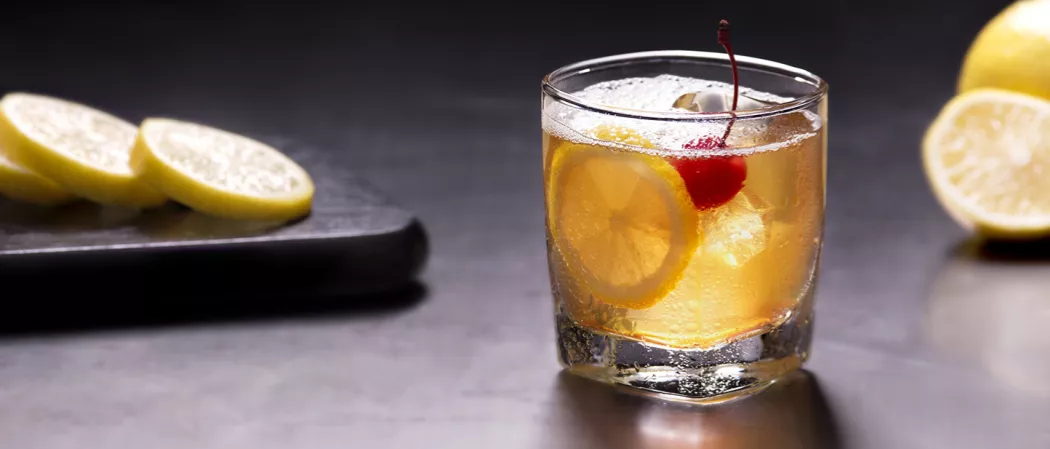 Glass of Amaretto Sour garnished with lemon slice and a cherry