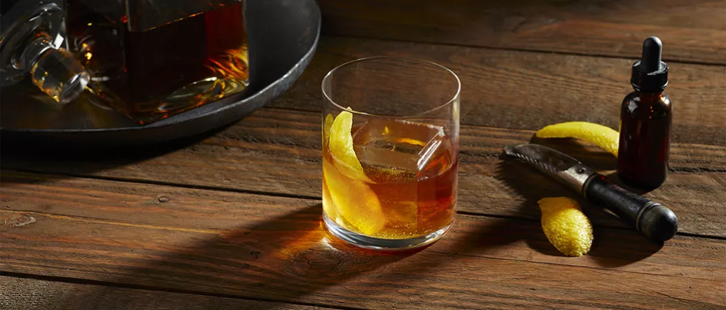 A glass of  Knob Creek® Rye Old Fashioned garnished with Lemon Peel along with Angostura® Bitters