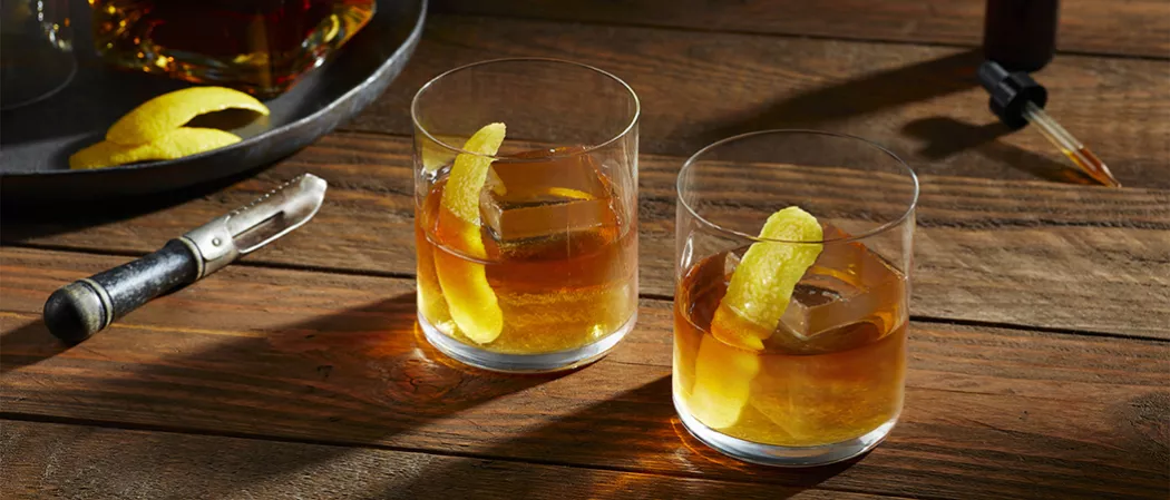 Two glasses of  Knob Creek® Rye Old Fashioned garnished with Lemon Peel along with Angostura® Bitters