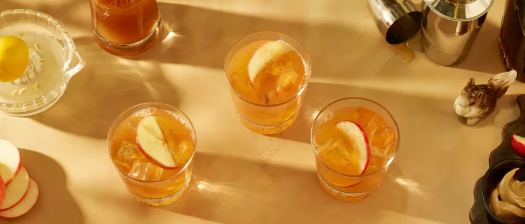 Three glasses of SQRRL® An Apple A Day garnished with Fresh Apple Slices 