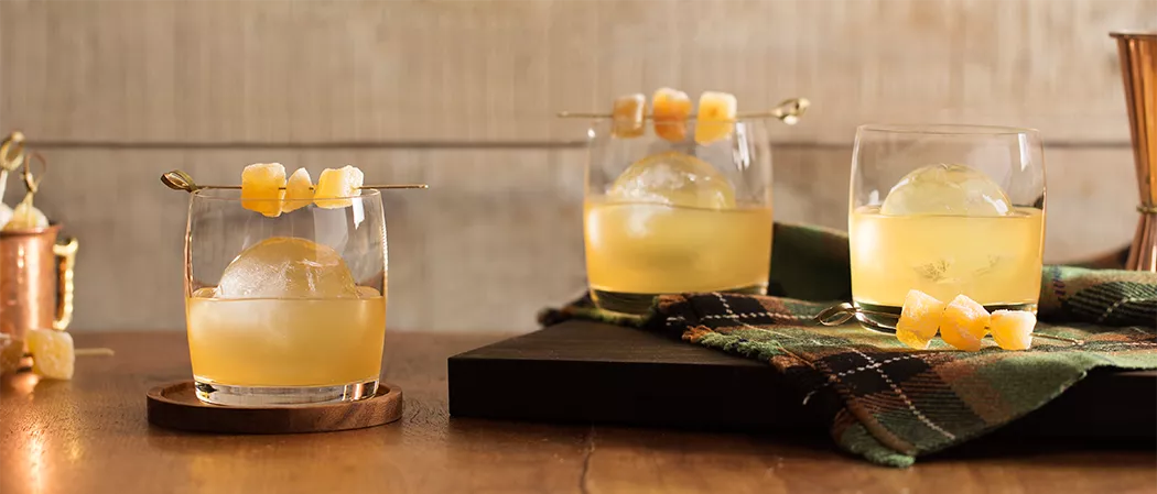 Three glasses of Laphroaig® Penicillin garnished with candied ginger