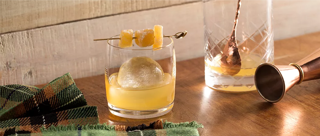 Glass of Laphroaig® Penicillin garnished with candied ginger